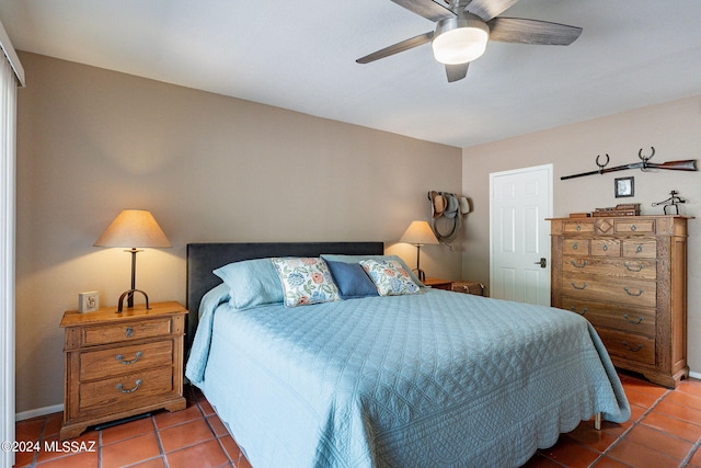 bedroom with a ceiling fan, tile patterned floors, and baseboards
