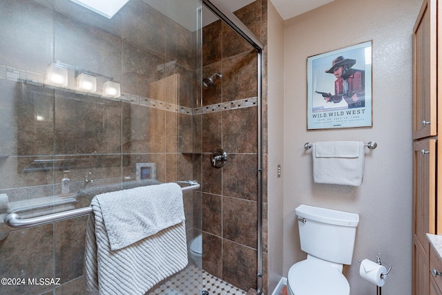 bathroom featuring vanity, toilet, and a shower with shower door