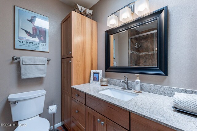 bathroom with walk in shower, vanity, and toilet