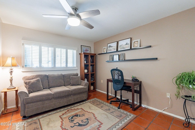 tiled office with a ceiling fan and baseboards