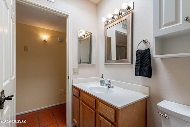 half bathroom with toilet, baseboards, tile patterned flooring, and vanity