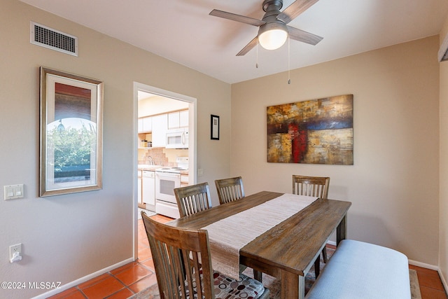 dining space with visible vents, baseboards, ceiling fan, and tile patterned flooring