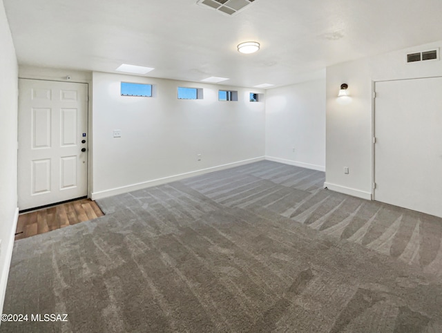 basement featuring dark carpet