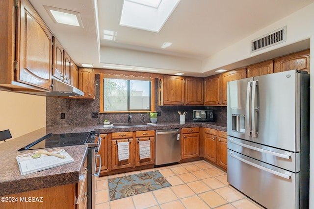 kitchen with sink, light tile patterned floors, stainless steel appliances, and tasteful backsplash