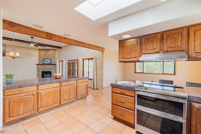 kitchen featuring ceiling fan, a fireplace, beamed ceiling, stainless steel range with electric stovetop, and light tile patterned floors