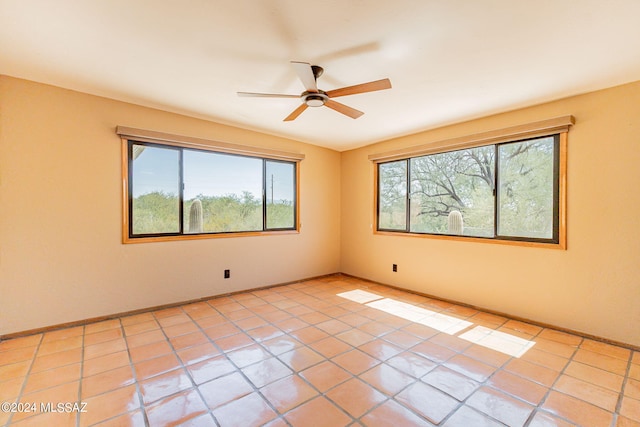 tiled spare room with ceiling fan and plenty of natural light