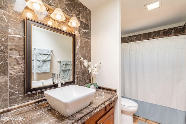 bathroom with tile walls, toilet, vanity, and walk in shower