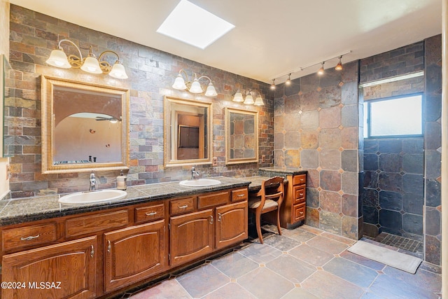 bathroom with a shower, vanity, and a skylight