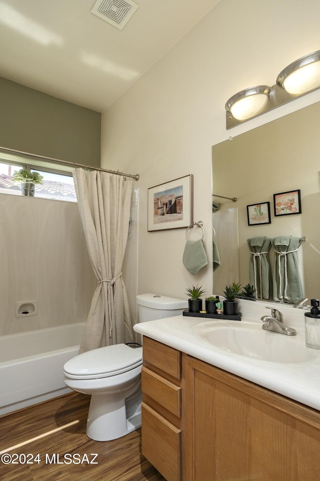 full bathroom with shower / tub combo with curtain, vanity, hardwood / wood-style flooring, and toilet