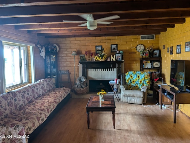 living room featuring hardwood / wood-style flooring, ceiling fan, and beam ceiling