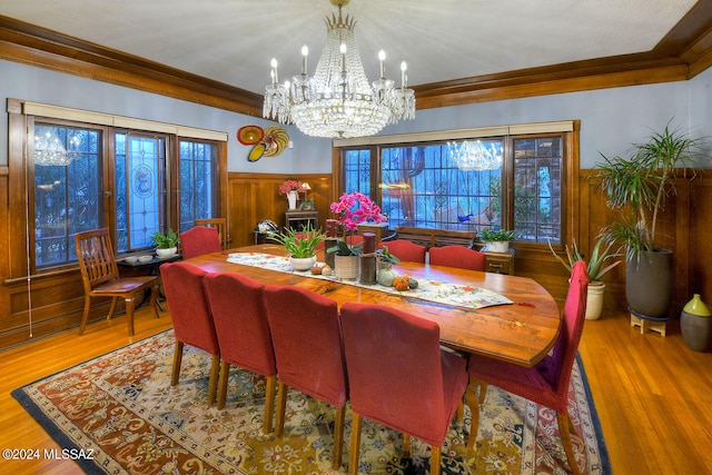 dining room with crown molding, light hardwood / wood-style flooring, and a notable chandelier