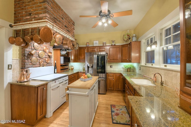 kitchen with appliances with stainless steel finishes, light hardwood / wood-style floors, sink, wooden counters, and ceiling fan