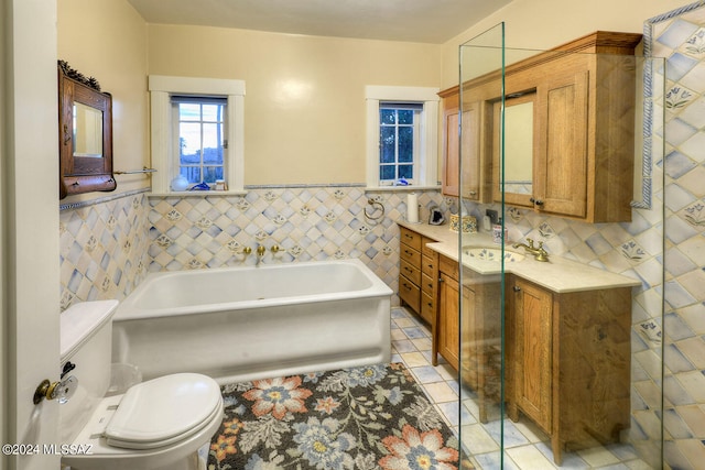 bathroom with tile patterned flooring, toilet, a bath, tile walls, and vanity