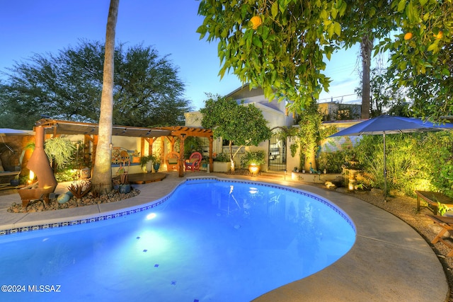 pool at dusk featuring a pergola and a patio