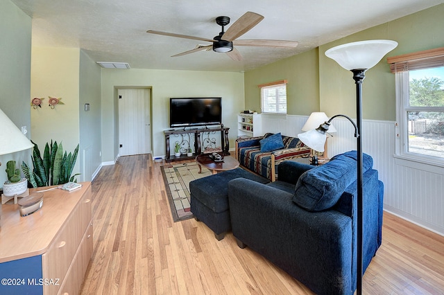 living room with plenty of natural light, ceiling fan, and light hardwood / wood-style floors