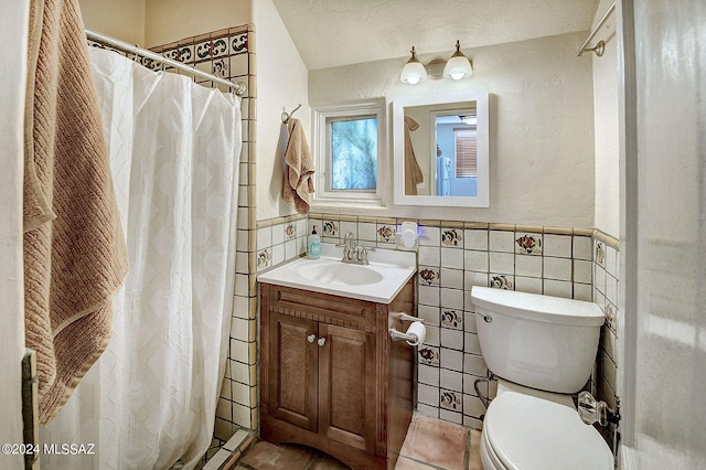 bathroom featuring a textured ceiling, tile walls, toilet, and vanity