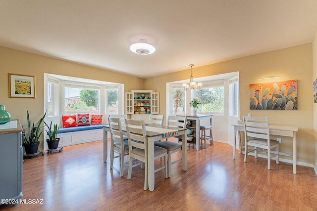 dining room with light wood-type flooring and a chandelier