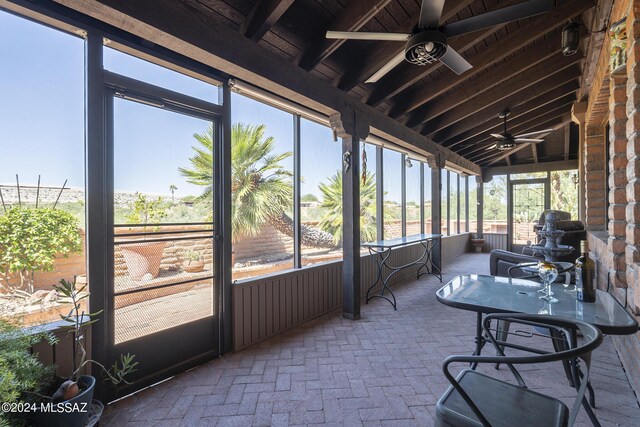 sunroom / solarium featuring a wealth of natural light, ceiling fan, and lofted ceiling