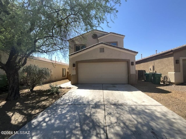 view of front of property featuring stucco siding, driveway, and a garage