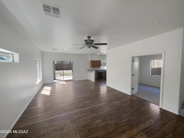 unfurnished living room featuring visible vents, baseboards, dark wood-type flooring, and ceiling fan