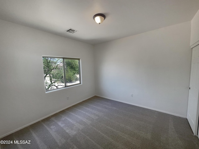 empty room with carpet flooring, baseboards, and visible vents