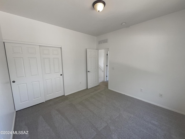 unfurnished bedroom featuring visible vents, baseboards, carpet, and a closet