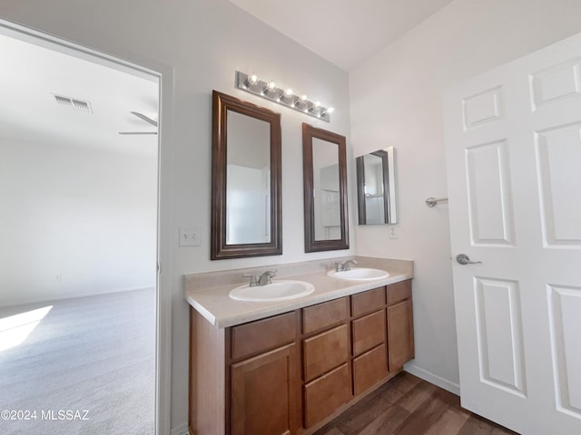 bathroom with double vanity, visible vents, baseboards, and a sink