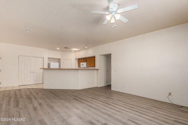 unfurnished living room with ceiling fan and light hardwood / wood-style floors