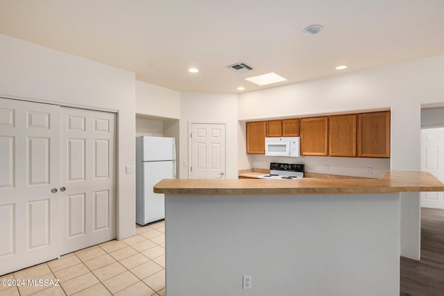 kitchen with white appliances and light tile patterned flooring