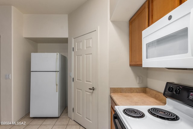 kitchen with white appliances and light tile patterned floors