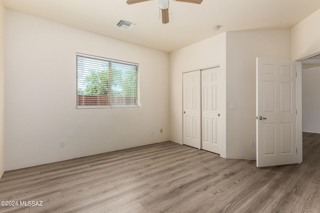 unfurnished bedroom with light hardwood / wood-style flooring, ceiling fan, and a closet