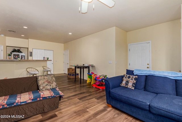 living room with ceiling fan and dark hardwood / wood-style flooring