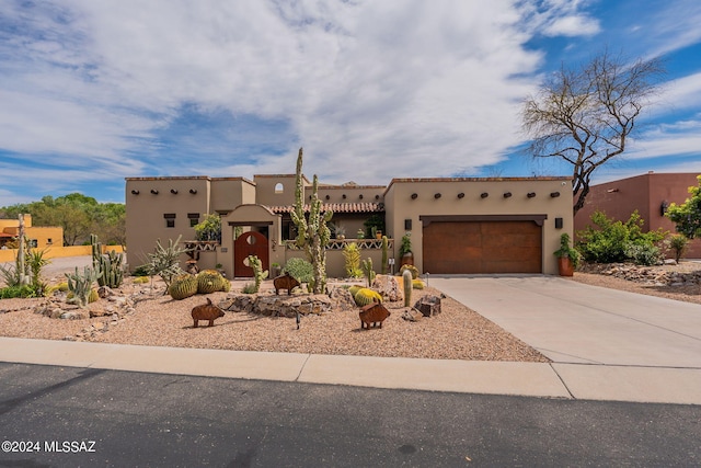 pueblo-style house featuring a garage