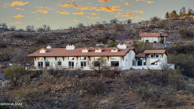 view of front facade with a chimney and stucco siding