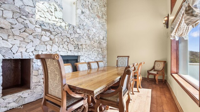 dining room with hardwood / wood-style flooring and a fireplace