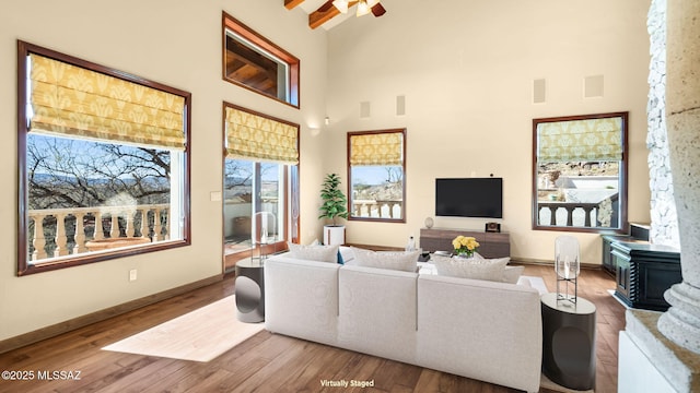living room featuring baseboards, wood finished floors, visible vents, and high vaulted ceiling