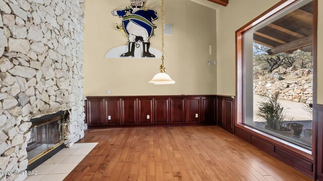 interior space with a fireplace, high vaulted ceiling, light hardwood / wood-style flooring, and beam ceiling