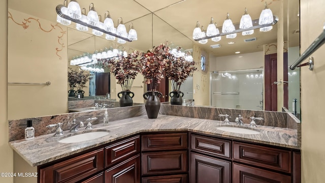 full bath featuring double vanity, a stall shower, and a sink