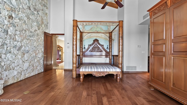 sitting room with visible vents, a ceiling fan, a high ceiling, and wood finished floors