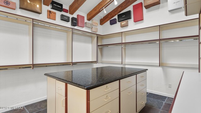 spacious closet featuring vaulted ceiling with beams