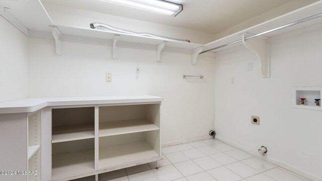 washroom with hookup for a washing machine, hookup for an electric dryer, and tile patterned flooring