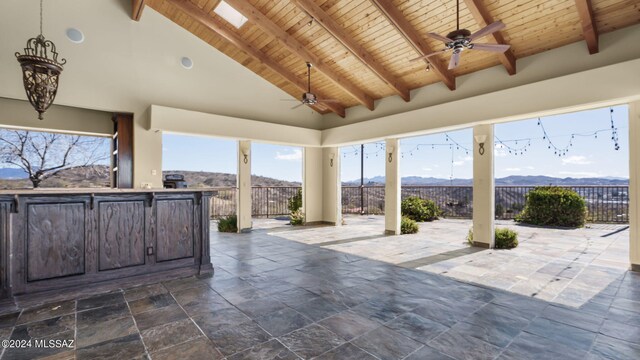 view of patio featuring a bar, ceiling fan, and a mountain view