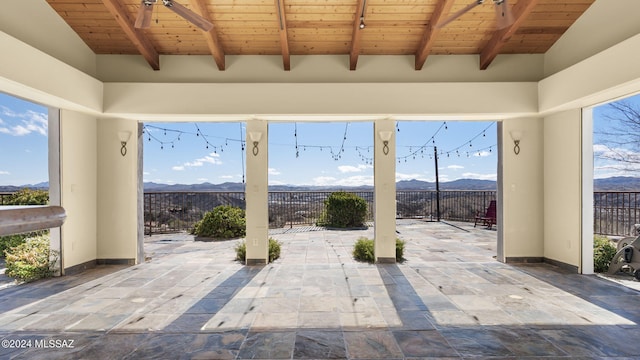 view of patio / terrace with fence and a mountain view