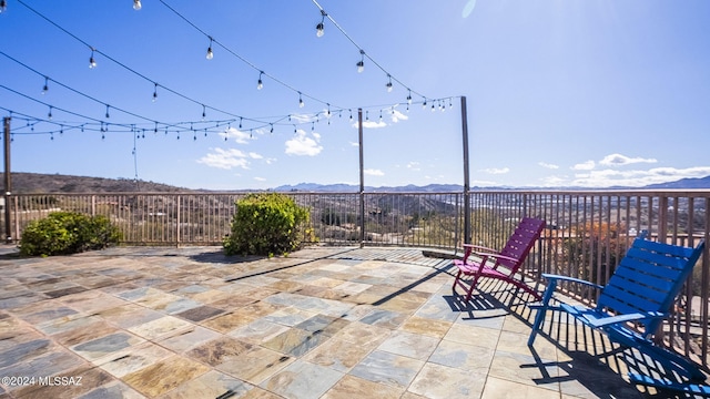 view of patio / terrace with a mountain view and fence