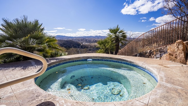 view of swimming pool with a mountain view and an in ground hot tub