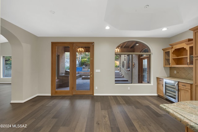 interior space with wine cooler, dark wood-type flooring, decorative backsplash, and a healthy amount of sunlight