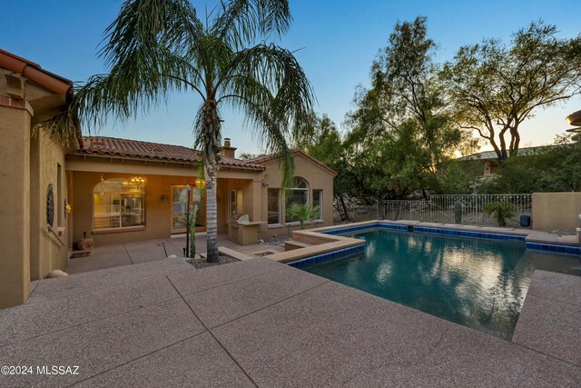 pool at dusk with a patio