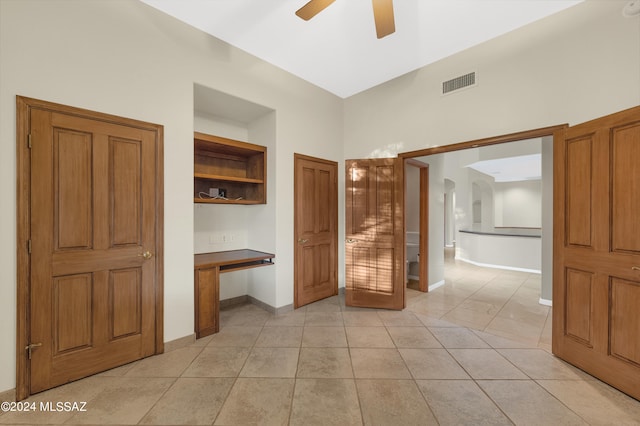 unfurnished bedroom with ceiling fan, ensuite bathroom, and light tile patterned floors