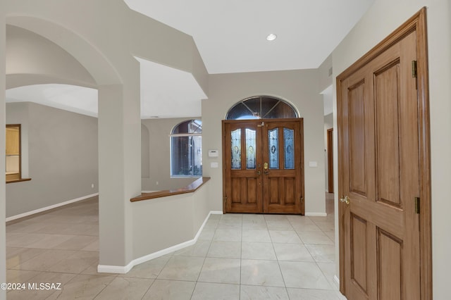 foyer featuring lofted ceiling and light tile patterned floors