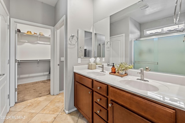 bathroom with tile patterned floors, walk in shower, and vanity